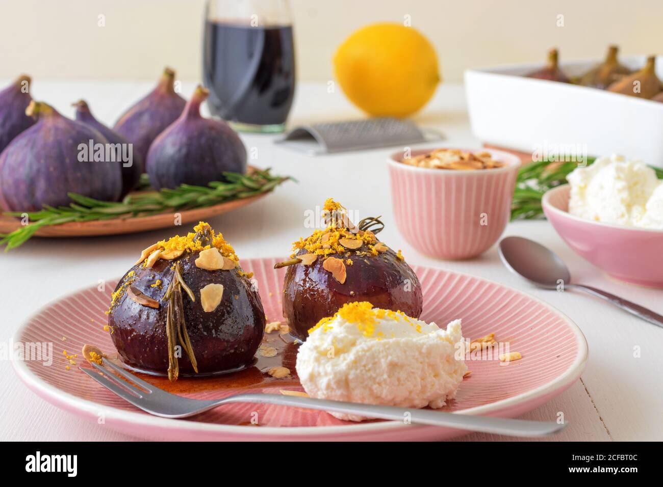 Karamellisierte Feigen mit Balsamico-Essig, Rosmarin, Mandeln und Quark. Langsam geröstete hausgemachte Frucht Dessert. Weißer Holztisch Hintergrund. Kein p Stockfoto