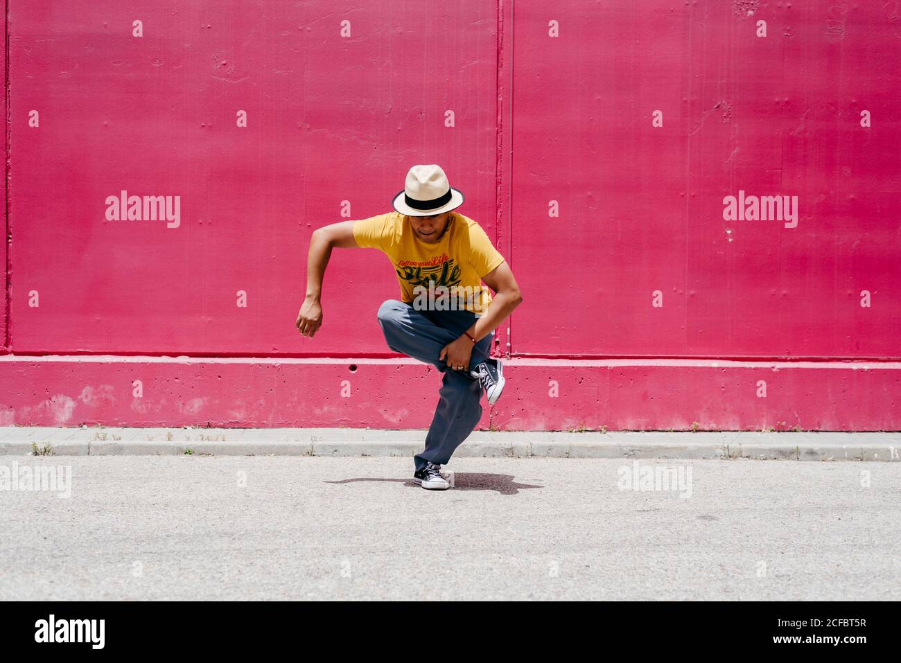 Junge hispanische Männer tanzen nahe einer rosa Wand Die Straße Stockfoto