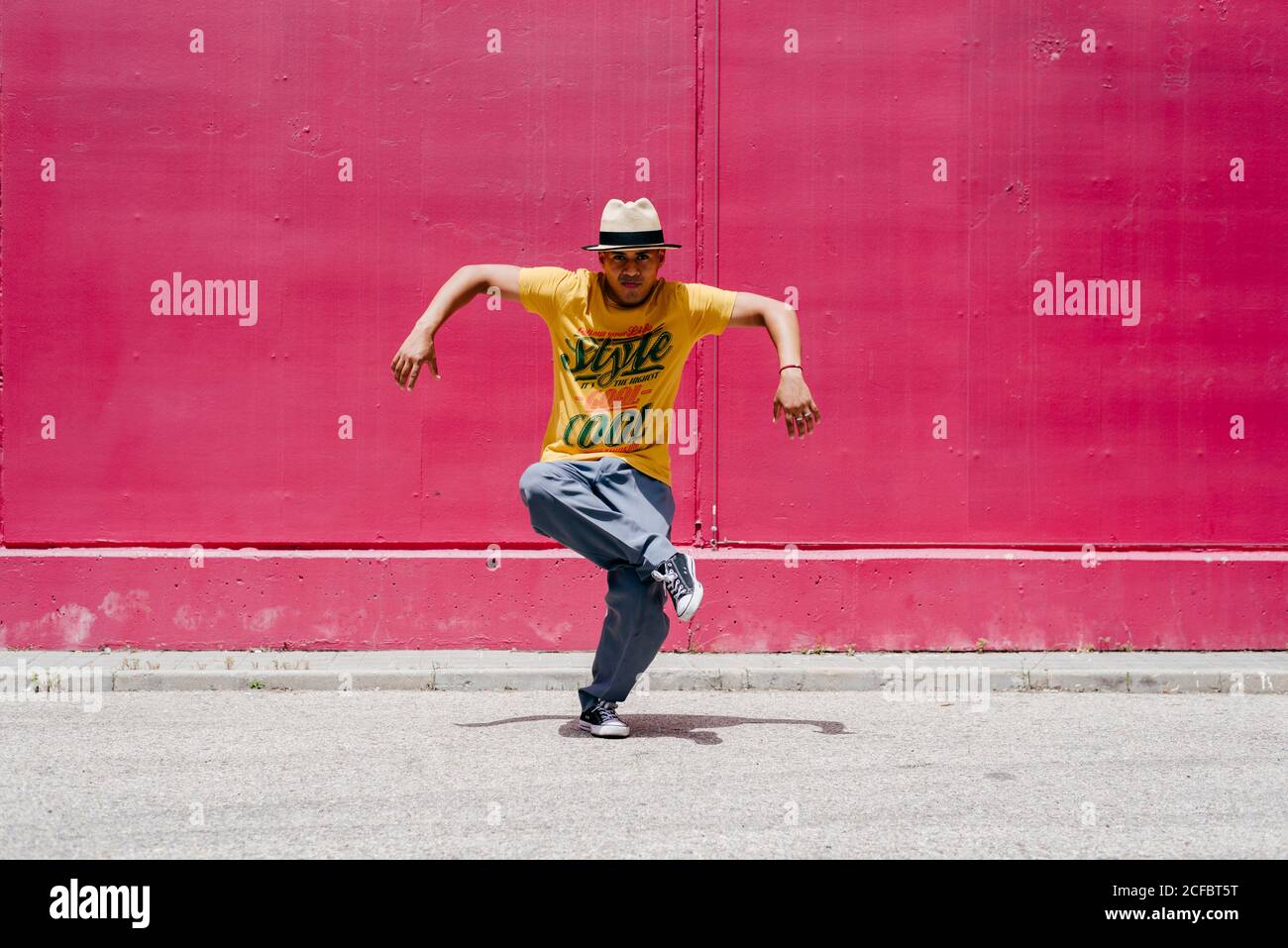 Junge hispanische Männer tanzen nahe einer rosa Wand Die Straße Stockfoto