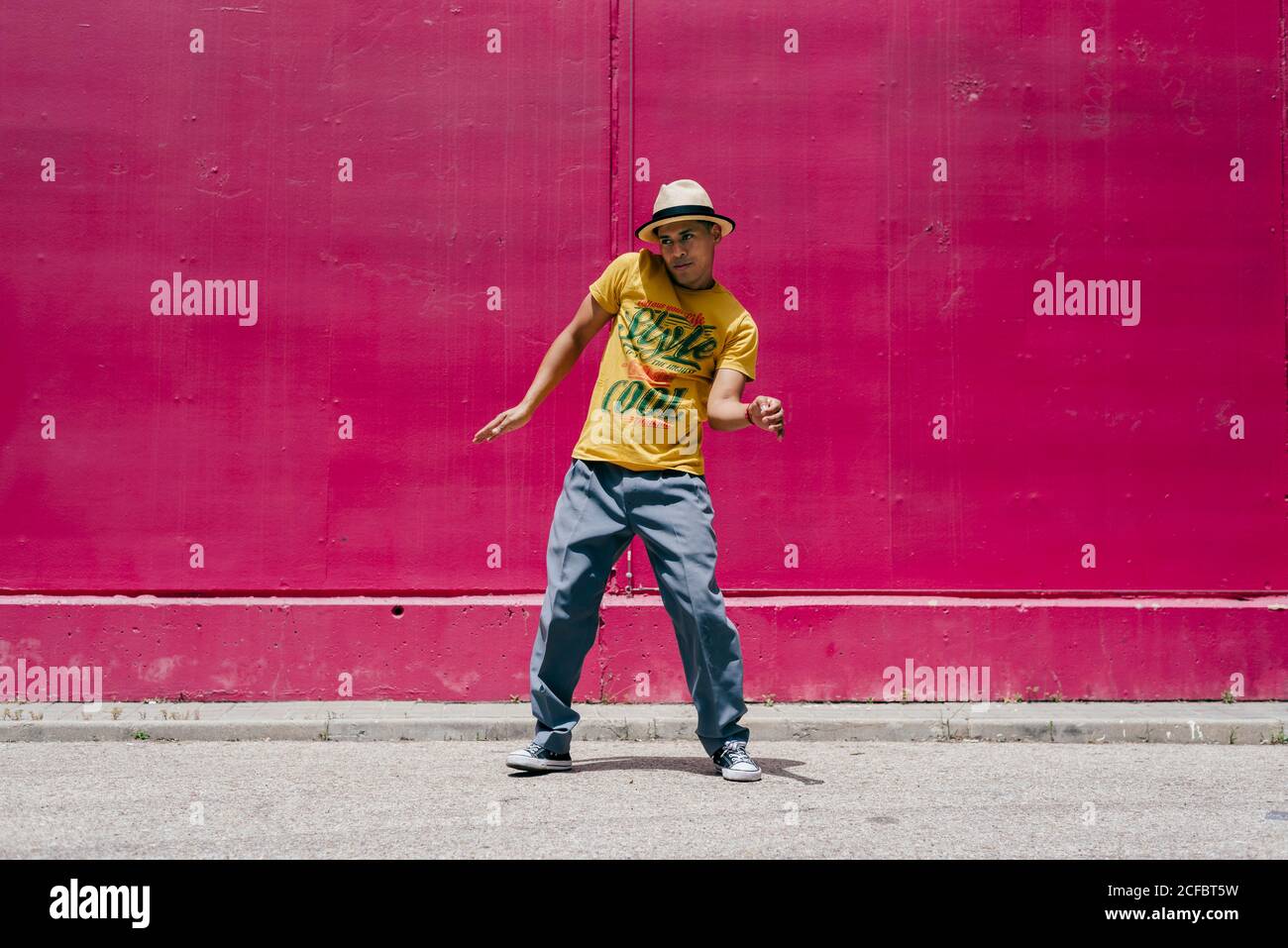 Junge hispanische Männer tanzen nahe einer rosa Wand Die Straße Stockfoto