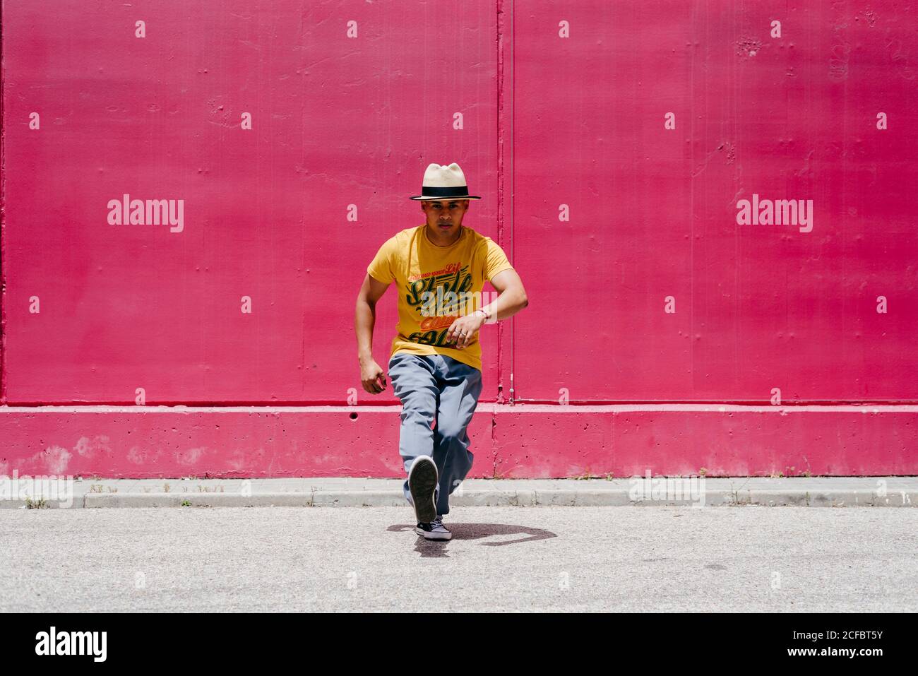 Junge hispanische Männer tanzen nahe einer rosa Wand Die Straße Stockfoto