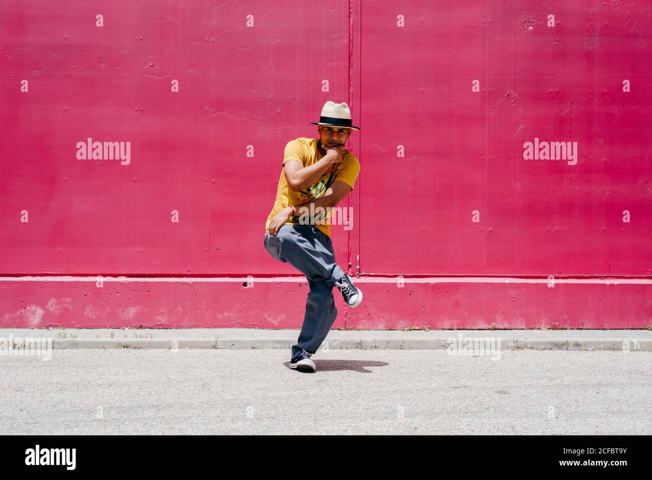 Junge hispanische Männer tanzen nahe einer rosa Wand Die Straße Stockfoto