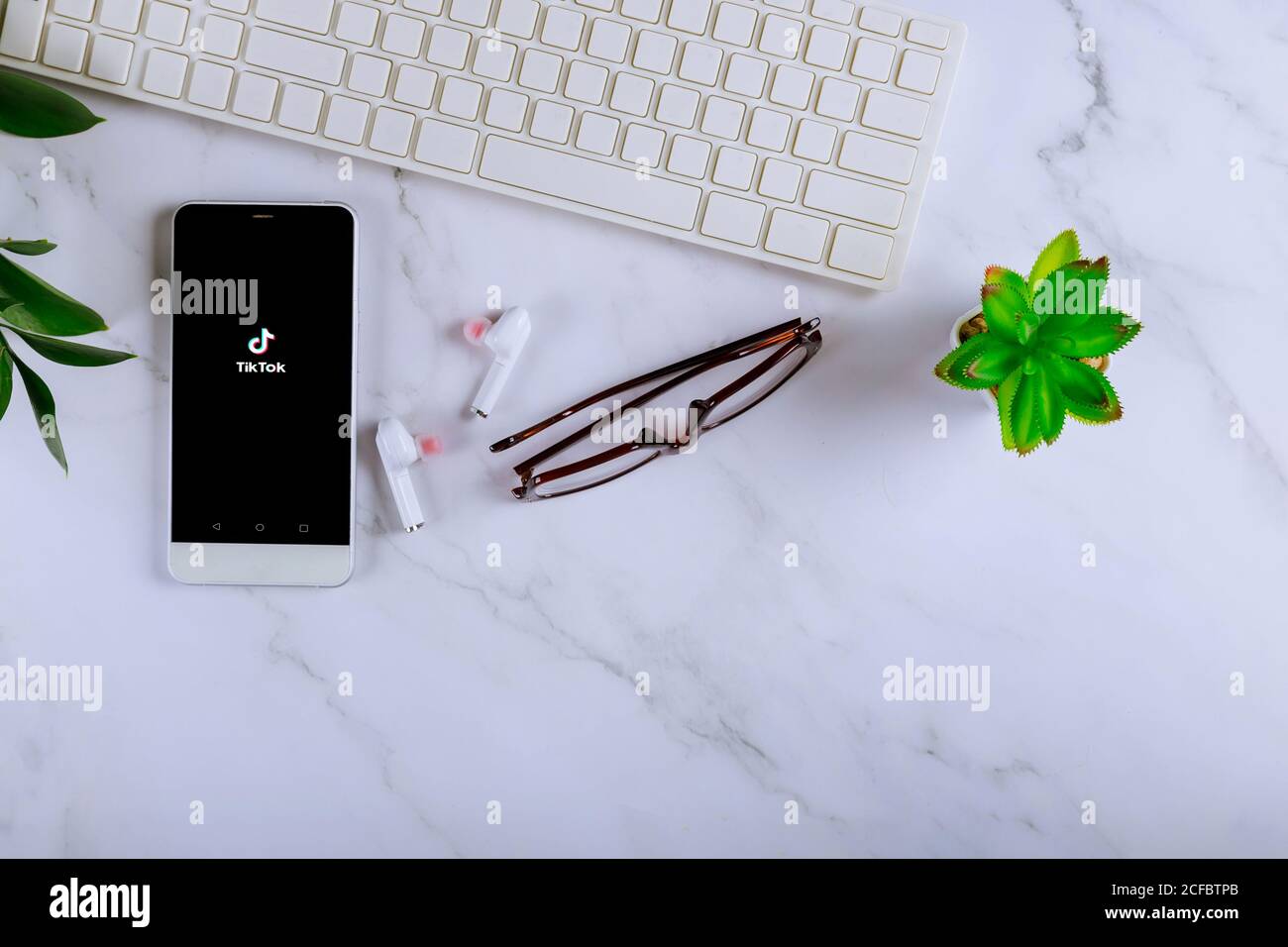 NEW YORK NY September 02 2020: TIK Tok Anwendung Symbol auf Smartphone-Bildschirm des Arbeitsplatzes Schreibtisch auf Computer Tastatur Brille Smartphone drahtlose Kopfhörer Stockfoto