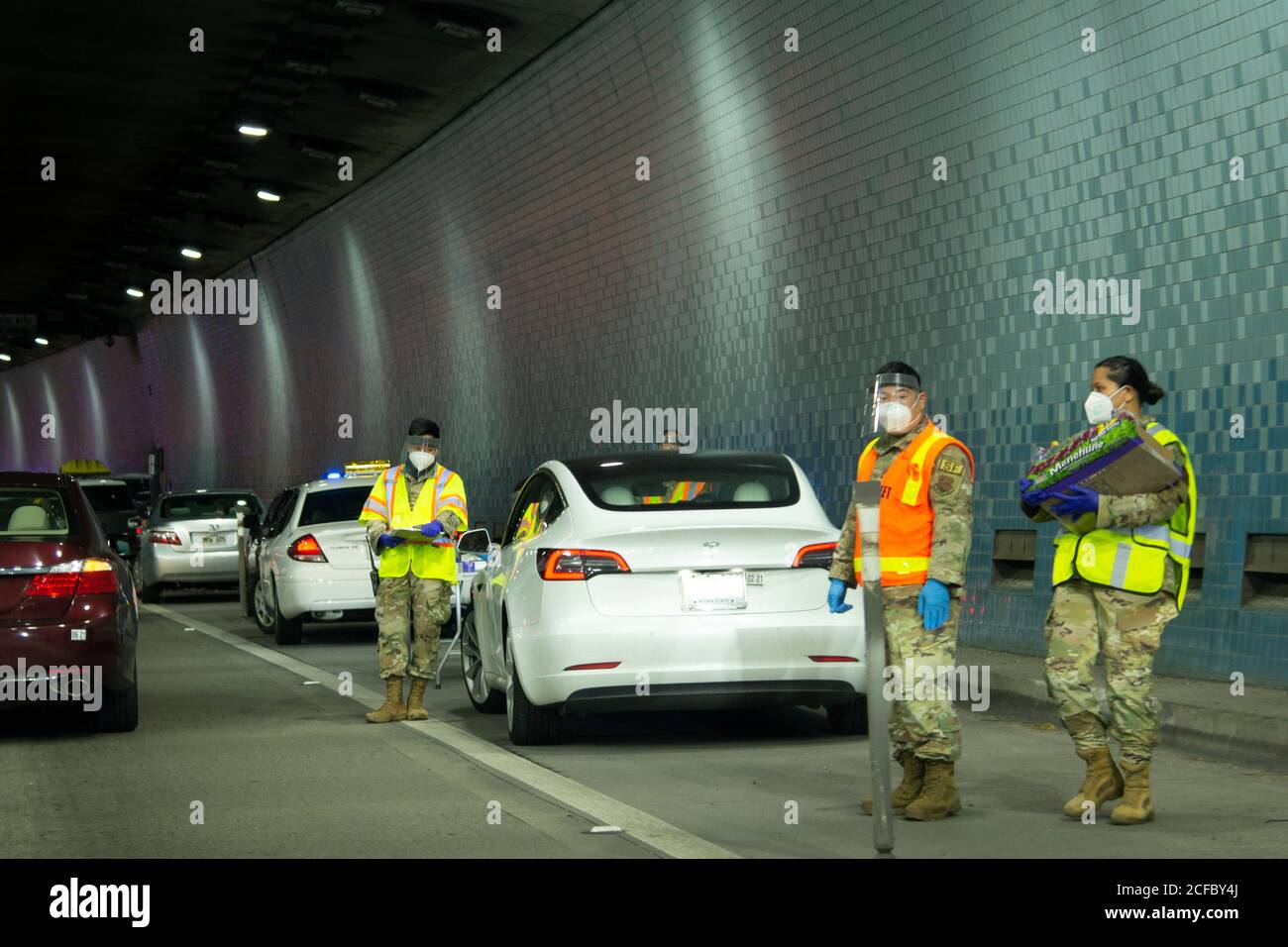 Militärpersonal in persönlicher Schutzausrüstung hilft bei der Durchführung von COVID-19-Massentests im Tunnel an der H3-Autobahn, Oahu, Hawaii, USA Stockfoto