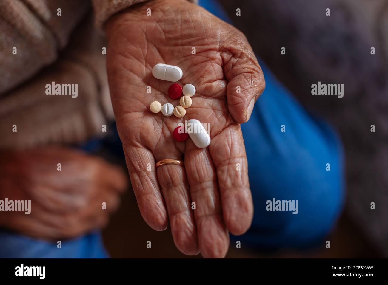 Detail der Pillen auf der Hand eines alten Mannes Stockfoto