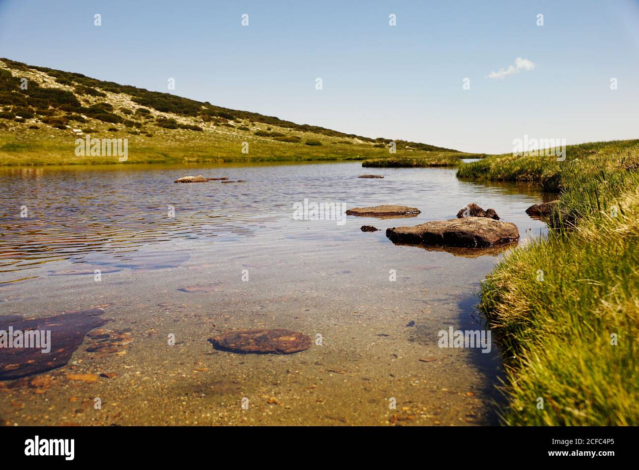 Klarer See am Fuße des felsigen Berges Stockfoto
