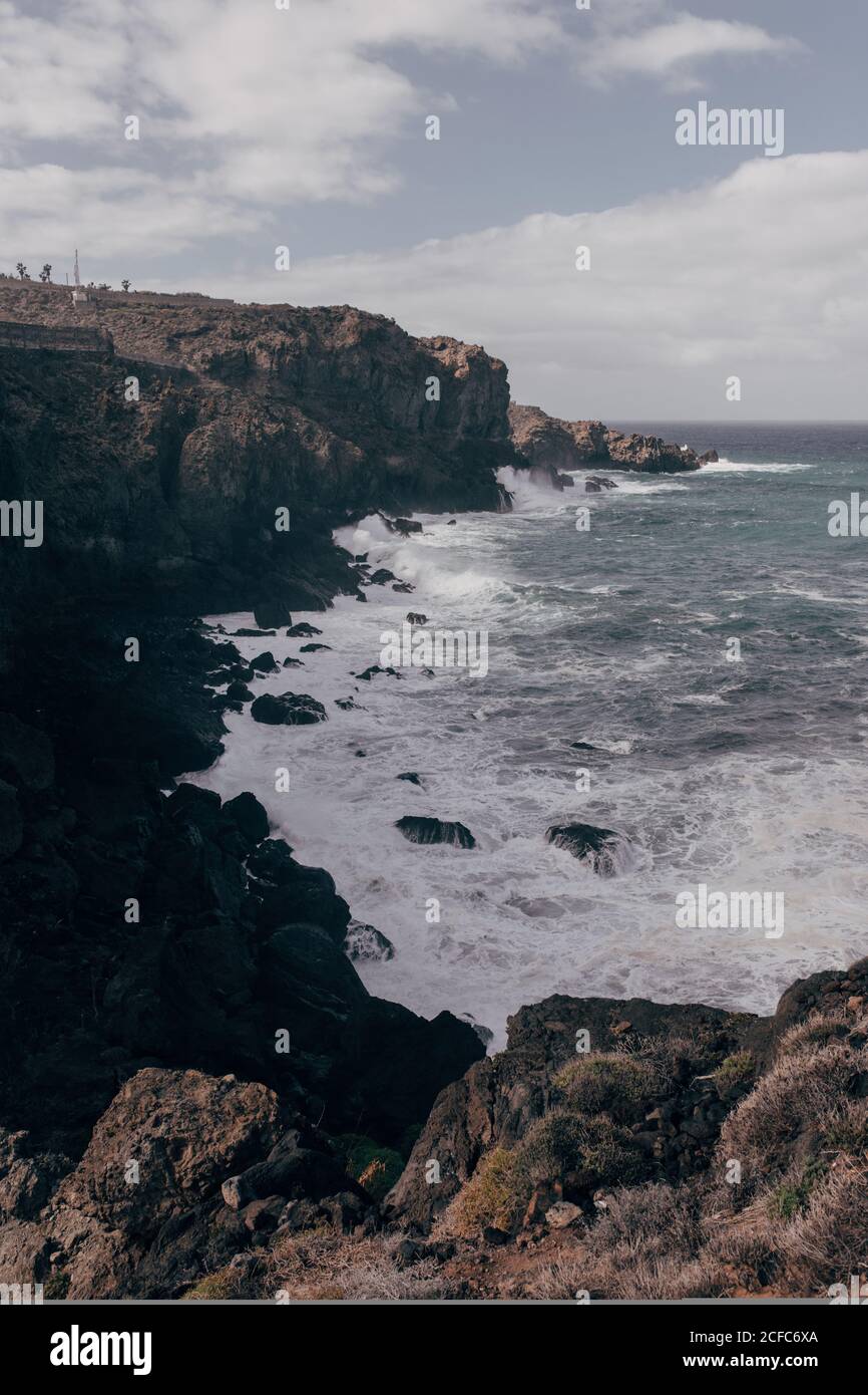 Malerische Küste mit riesigen Klippen und mächtigen Ozean Wellen schlagen auf Teneriffa entgegen Stockfoto