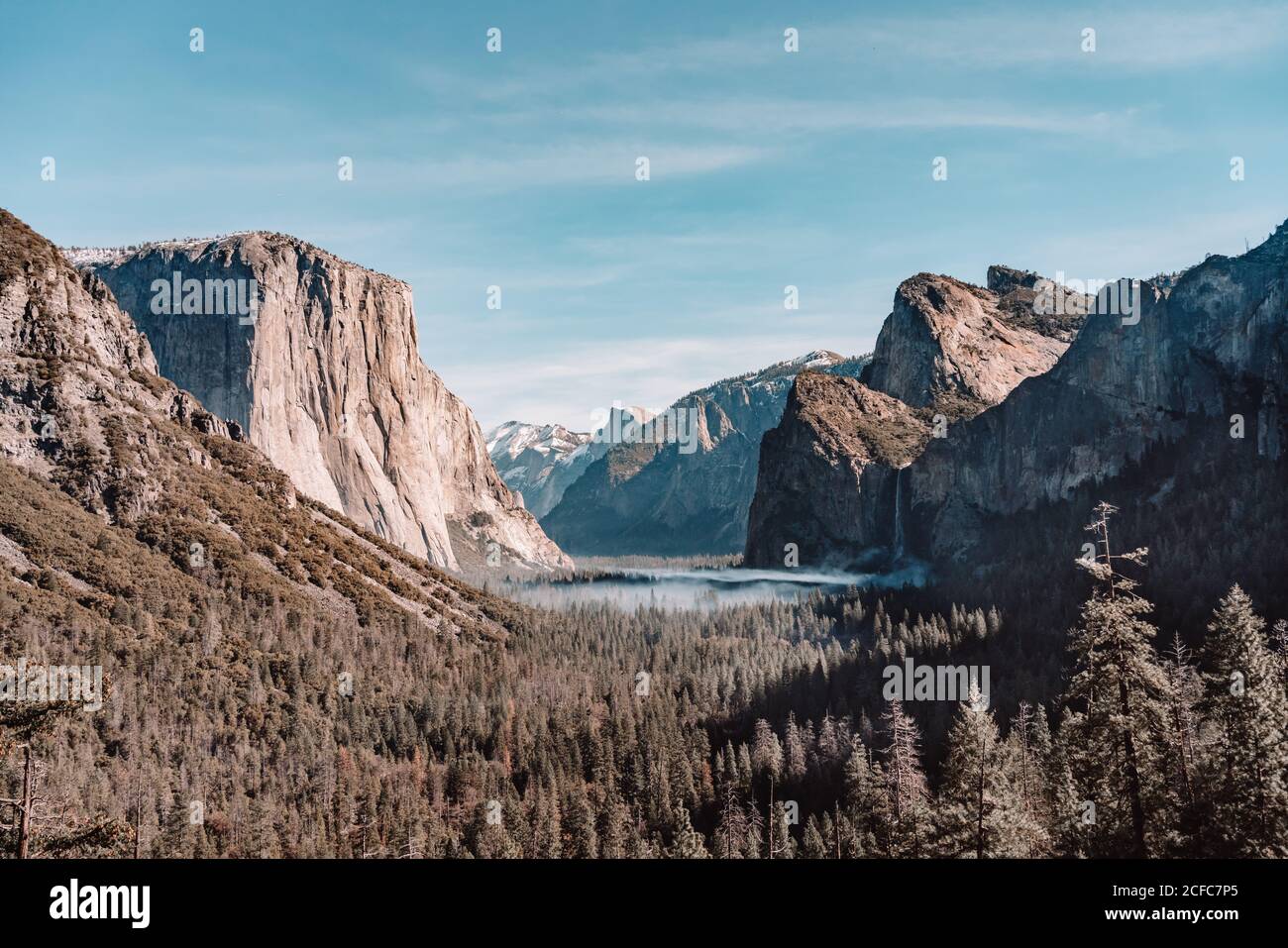 Spektakuläre Landschaft des Yosemite Valley mit See umgeben von Wald Und felsige Berge unter wolkenblauem Himmel im sonnigen Frühling Tag in Kalifornien Stockfoto