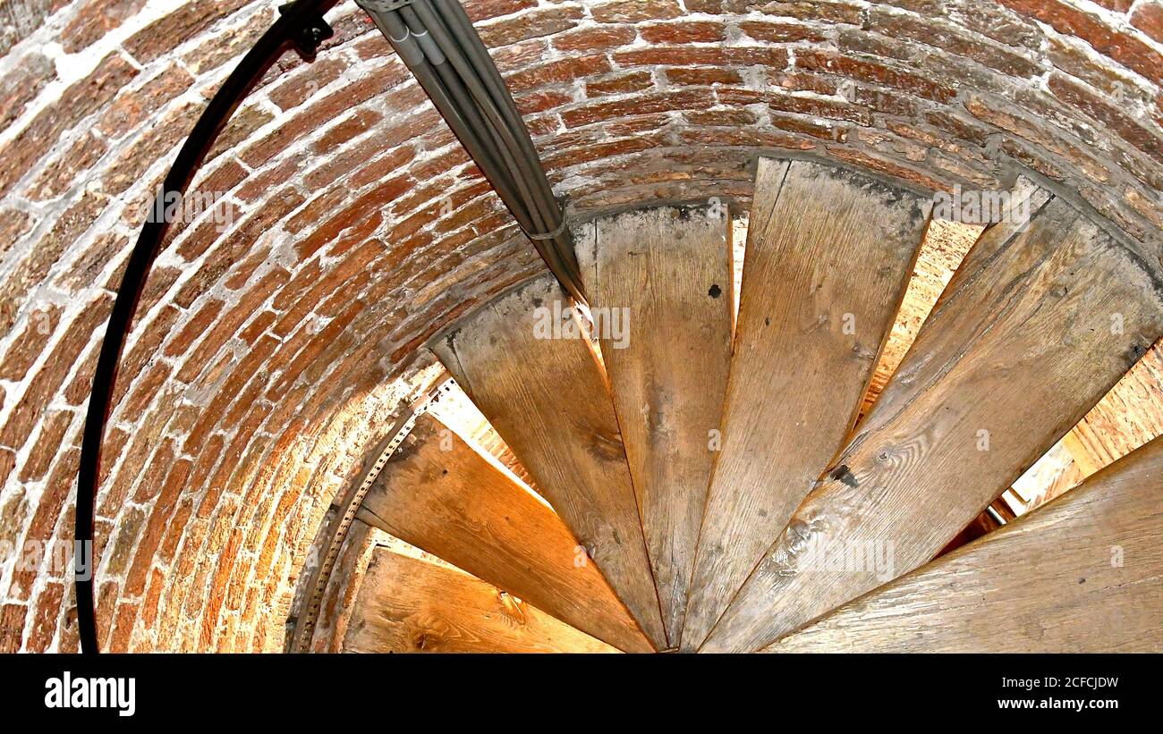 Blick hinunter eine alte hölzerne Wendeltreppe in einem Ziegelrundturm in einem alten mittelalterlichen Backstein Kirchturm. Stockfoto