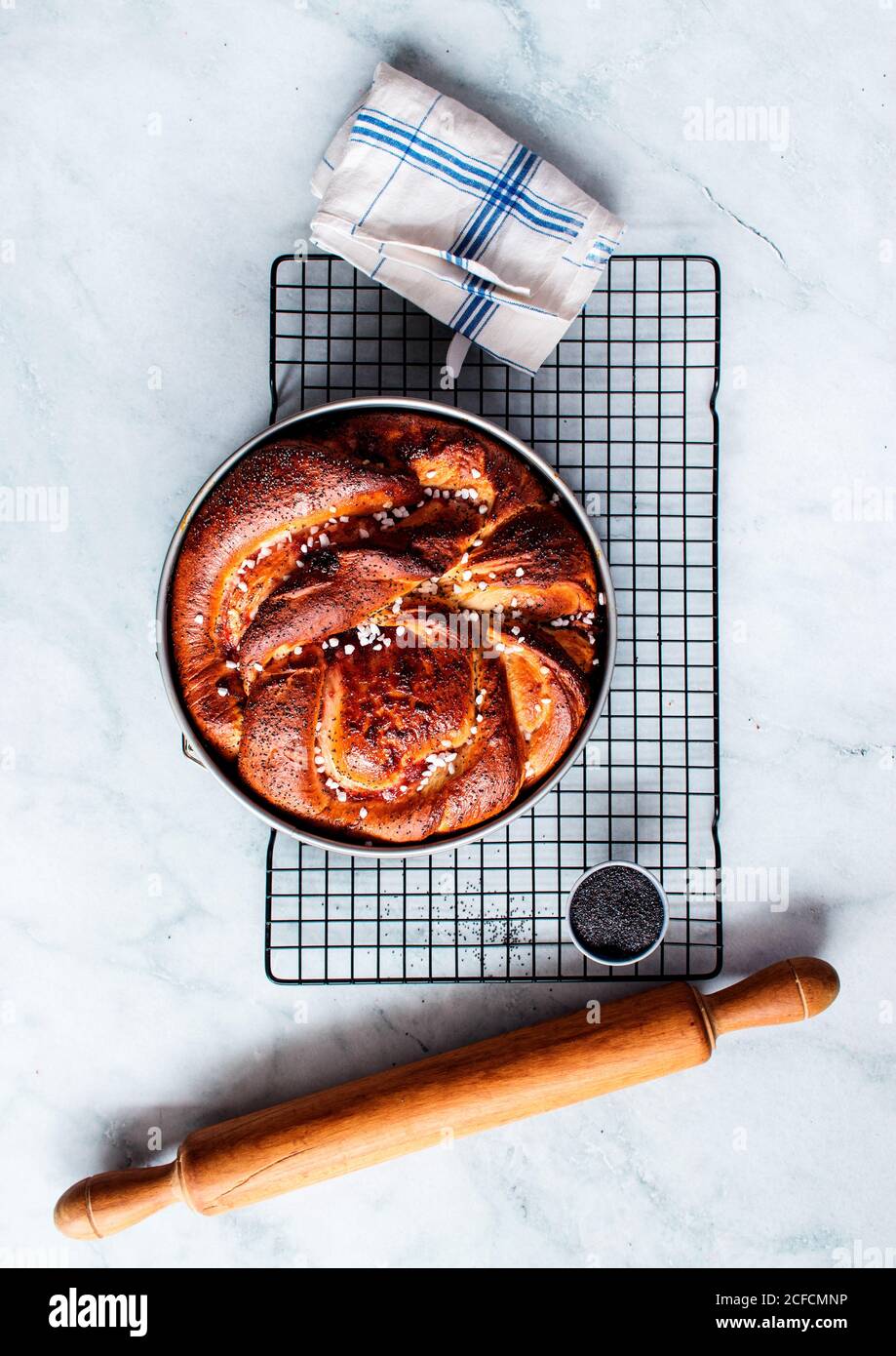 Von oben frische Erdbeer Brioche auf die Herstellung in der Nähe platziert Nudelholz und Küchenutensilien auf weißem, modernem Marmortisch Stockfoto