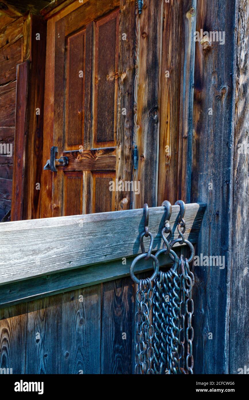 Hinter den Eisenketten am Balkongeländer ist die Tür zum ruhigen Dorf einer Bergfarm auf Zimmererberg Stockfoto