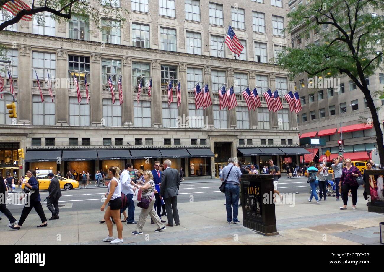 Saks Fifth Avenue Gebäude gesäumt mit amerikanischen Flaggen, New York City, USA Stockfoto