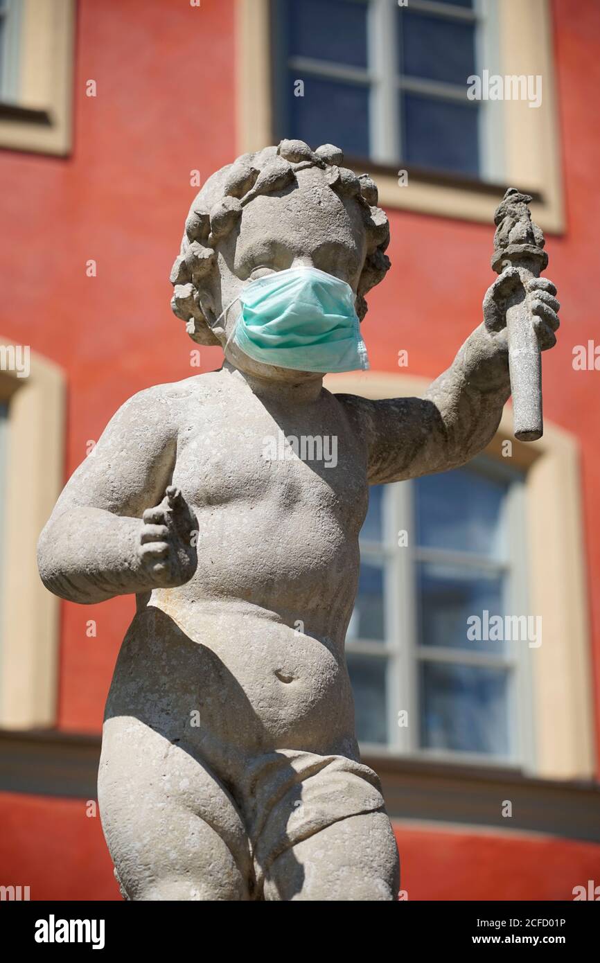 Deutschland, Bayern, Oberbayern, Mühldorf am Inn, Stadtplatzbrunnen, Brunnenbuberl, Brunnenfigur mit Schutzmaske, Virenschutz Stockfoto