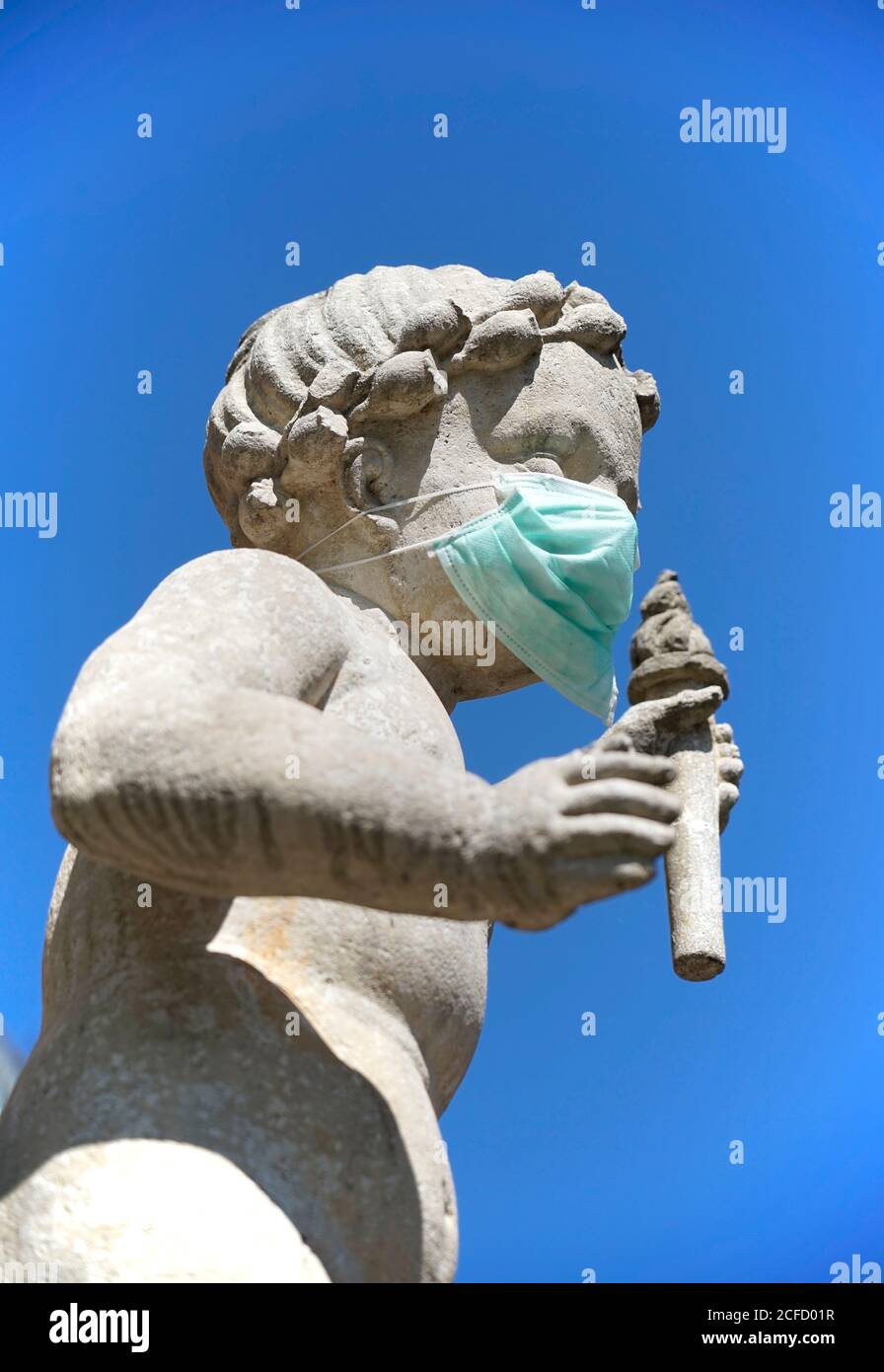 Deutschland, Bayern, Oberbayern, Mühldorf am Inn, Stadtplatzbrunnen, Brunnenbuberl, Brunnenfigur mit Schutzmaske, Virenschutz Stockfoto