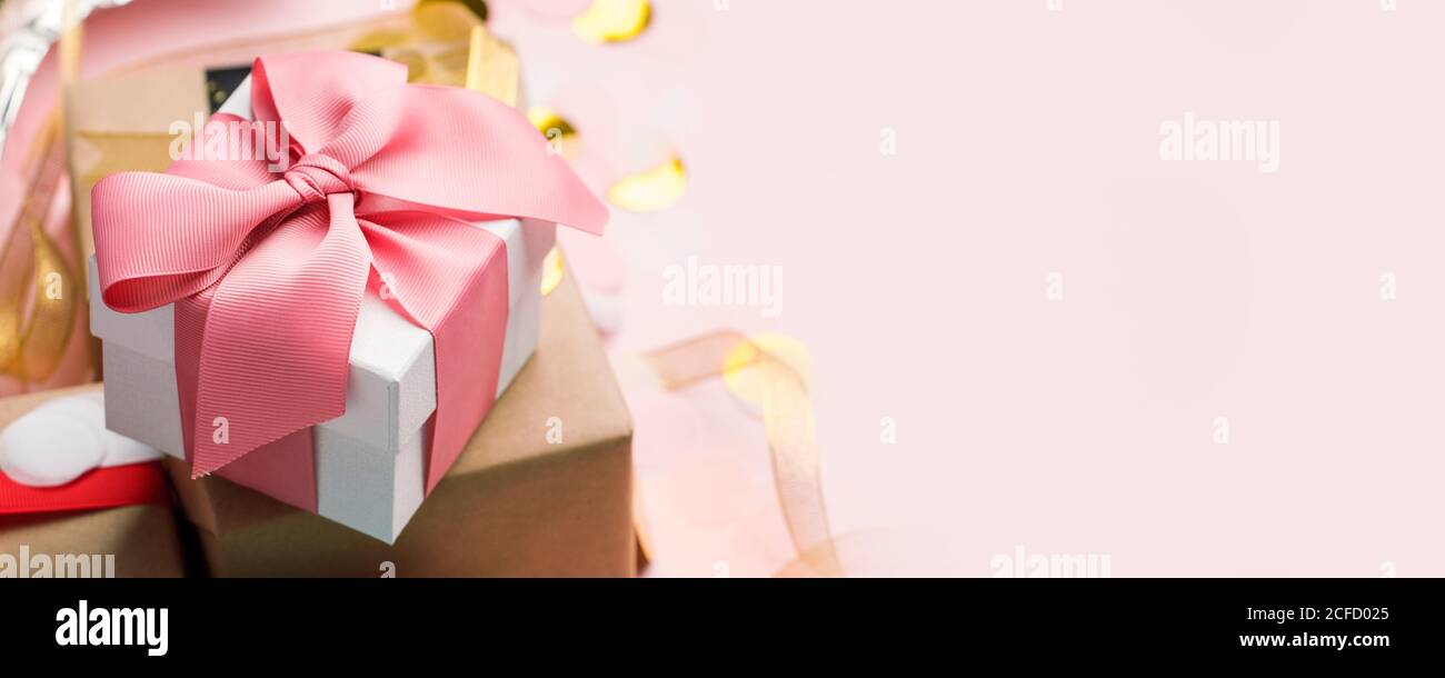 Holiday Luxury stilvolle Geschenk Geschenkbox mit rosa Schleife auf rosa Hintergrund gebunden, mit Konfetti verziert. Geburtstag, Weihnachten, Neujahr, Muttertag, Sal Stockfoto