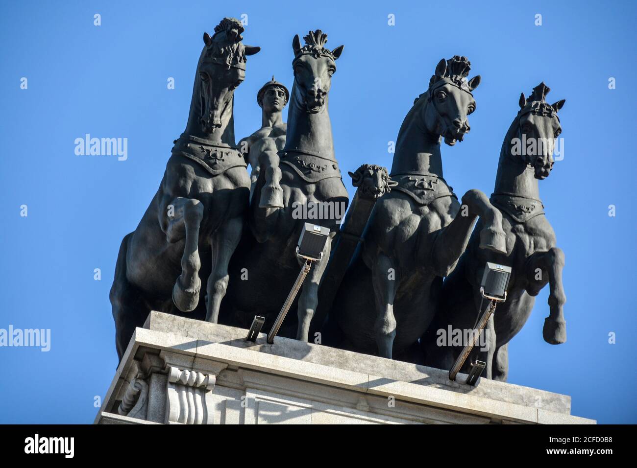 Eine große Statue eines Wagenwagens und vier Pferde auf einem Gebäude in der Innenstadt von Madrid, Spanien. Stockfoto