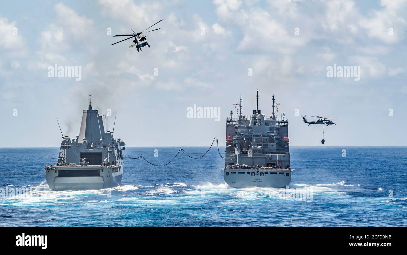 PHILIPPINISCHES MEER (Sept 3, 2020) das amphibische Transportschiff USS New Orleans (LPD 18), links, führt ein Nachschubschiff auf See mit dem trockenen Fracht-/Munitionsschiff USNS Charles Drew (T-AKE 10) mit MH-60S Sea Hawk Hubschraubern aus den „Erzengeln“ des Helicopter Sea Combat Squadron (HSC) 25, Abteilung 6. New Orleans, Teil der America Amphibious Ready Group, die zusammen mit der 31. Marine Expeditionary Unit dem Amphibious Squadron 11 zugewiesen wurde, ist im 7. Flottenbereich tätig, um die Interoperabilität mit Verbündeten und Partnern zu verbessern und als einsatzbereite Einsatztruppe zur Verteidigung des Friedens zu dienen Stockfoto