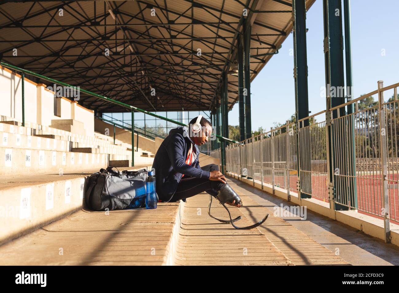 Männlicher Athlet mit Beinprothese auf der Treppe sitzend Stockfoto