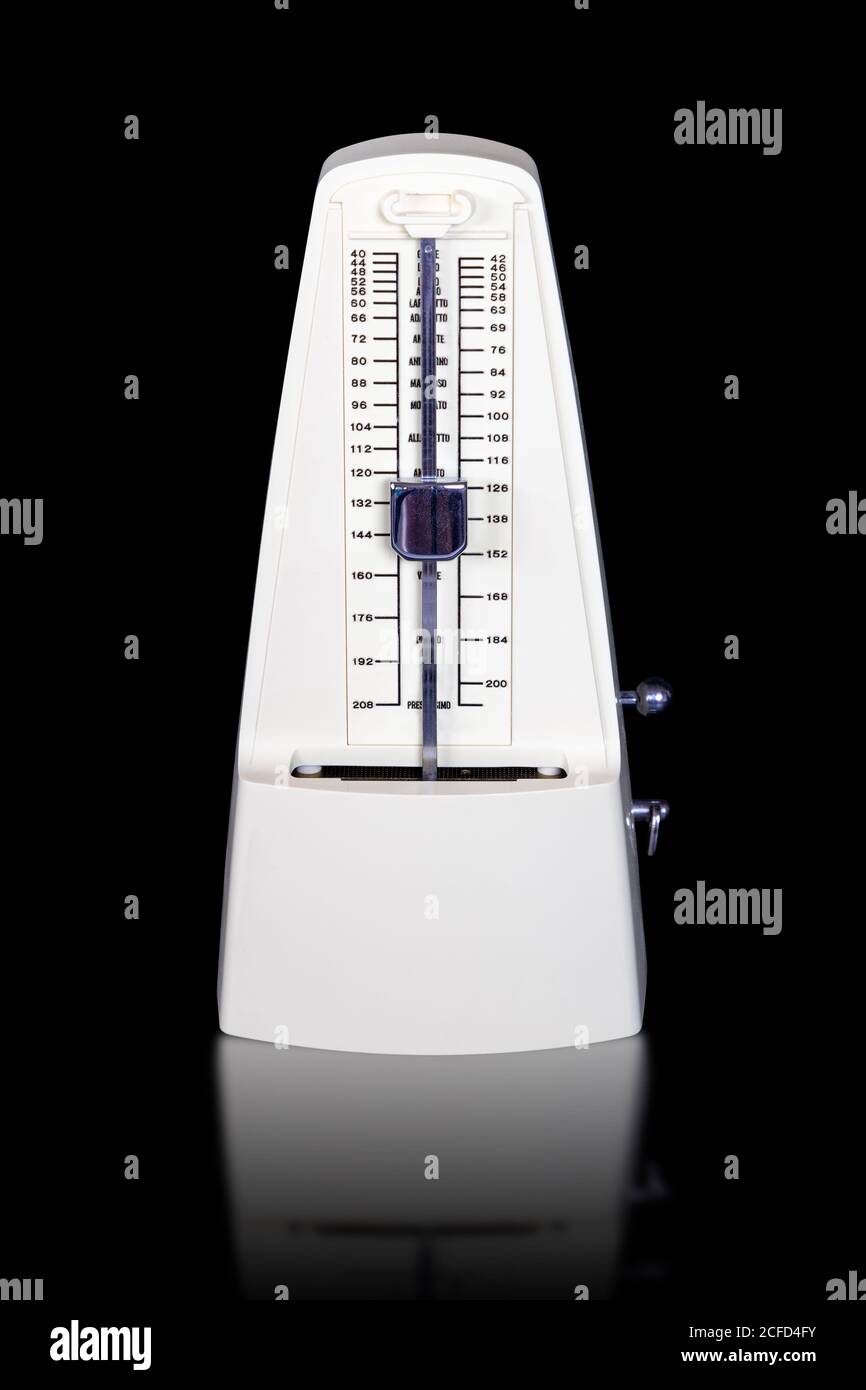 Weißes mechanisches Aufwickeln Metronom isoliert auf schwarzem Hintergrund mit Reflexionen. Stockfoto
