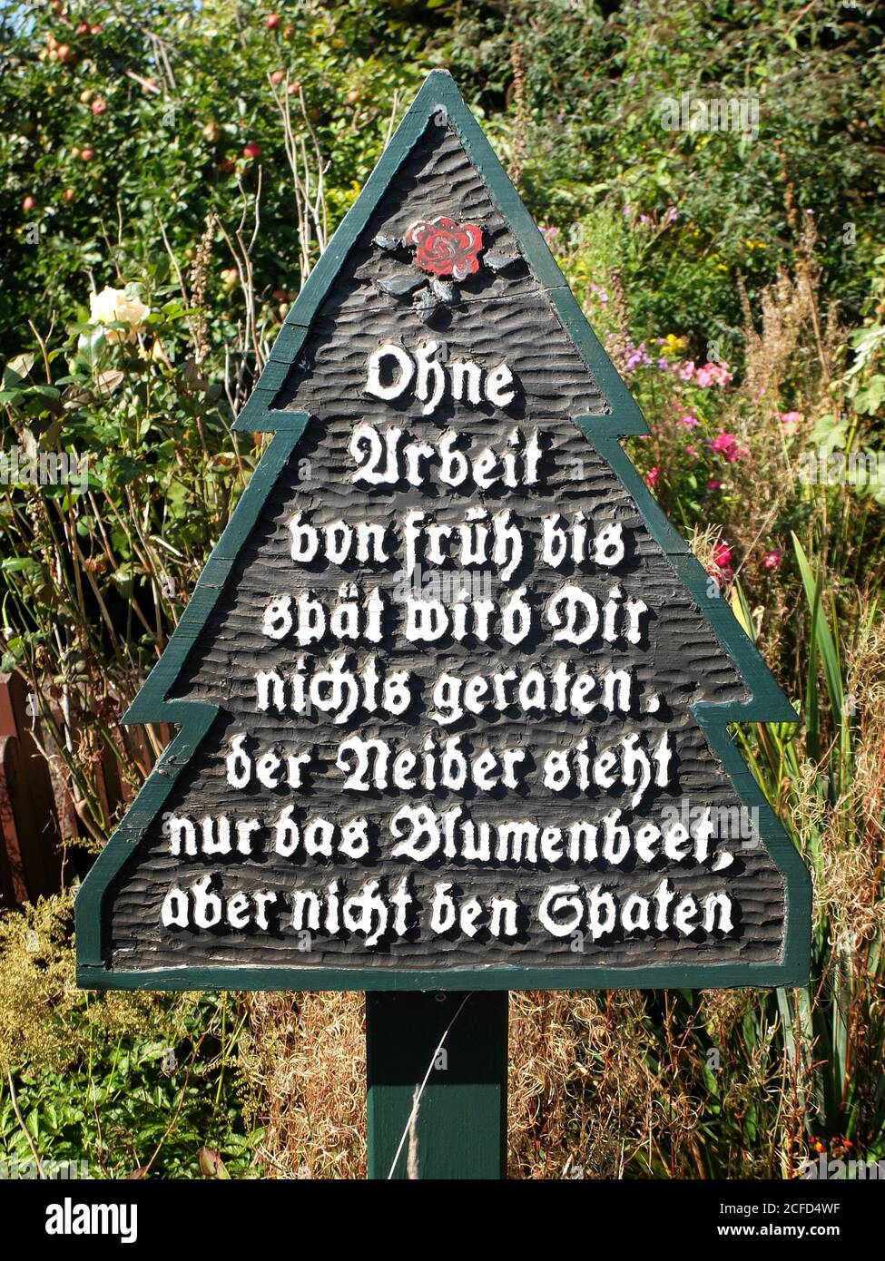 Schild mit Sprichwort im Garten Stockfoto