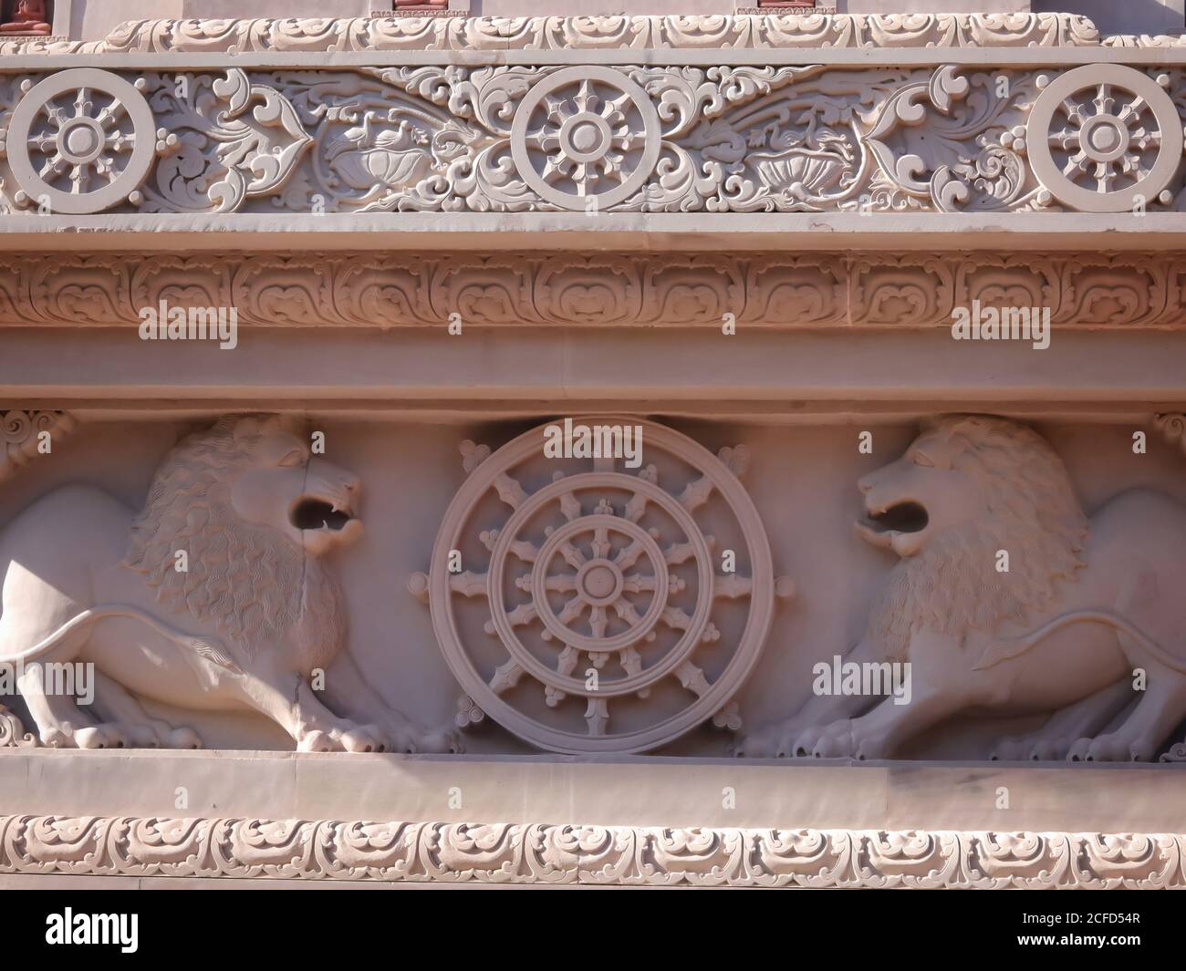 Logo des indischen Ashok Chakra mit Löwenkapitale an der Wand des buddhistischen Tempels mit selektivem Fokus. Schöne Architektur von Elefanten und Löwen auf Th Stockfoto