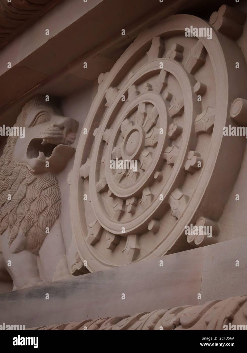 Logo des indischen Ashok Chakra mit Löwenkapitale an der Wand des buddhistischen Tempels mit selektivem Fokus. Schöne Architektur von Elefanten und Löwen auf Th Stockfoto