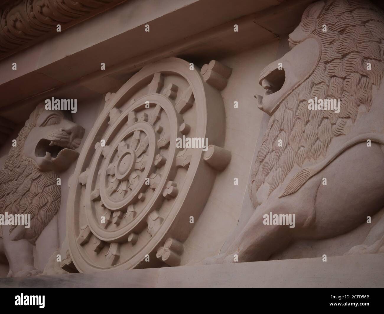 Logo des indischen Ashok Chakra mit Löwenkapitale an der Wand des buddhistischen Tempels mit selektivem Fokus. Schöne Architektur von Elefanten und Löwen auf Th Stockfoto
