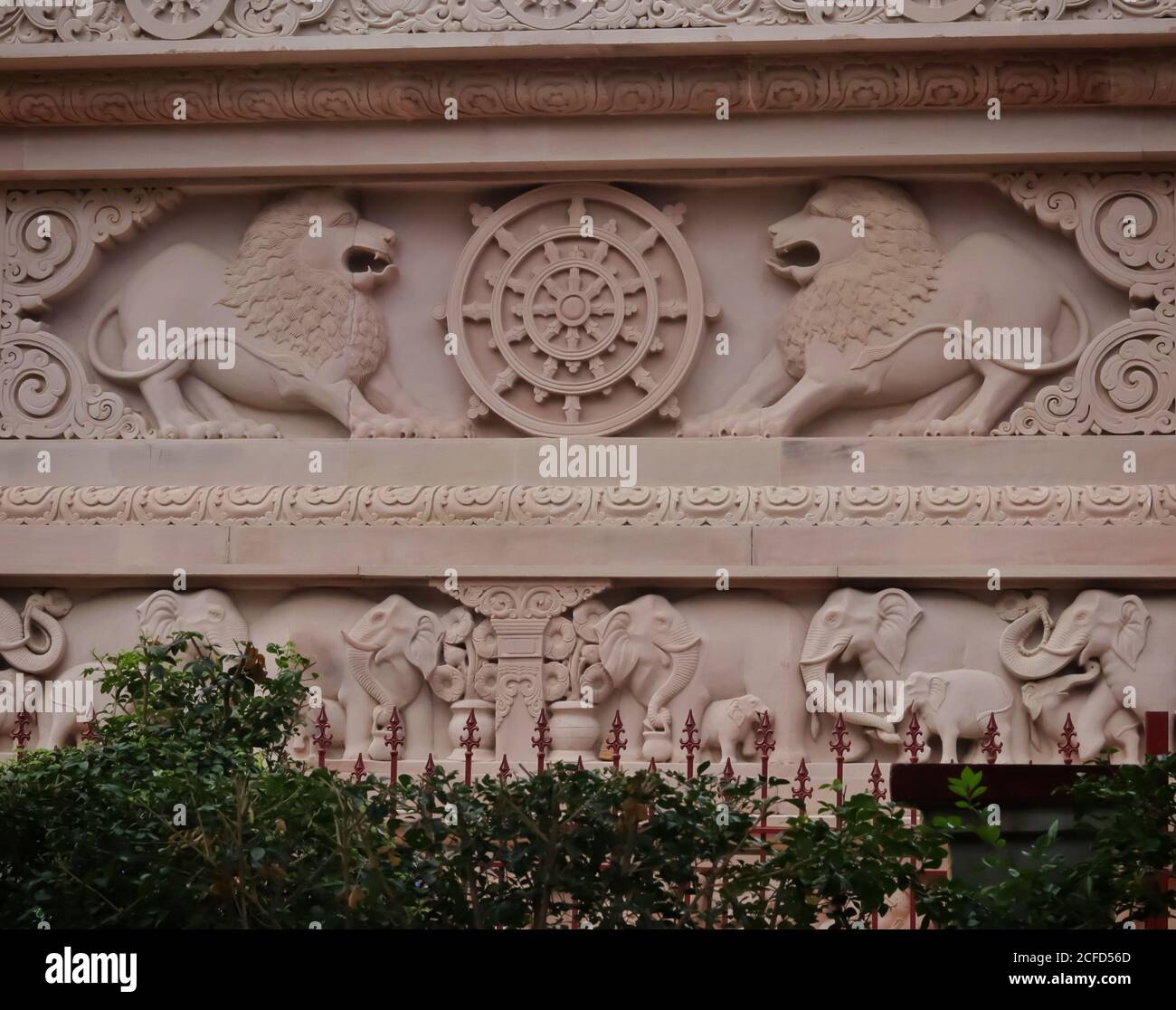 Logo des indischen Ashok Chakra mit Löwenkapitale an der Wand des buddhistischen Tempels mit selektivem Fokus. Schöne Architektur von Elefanten und Löwen auf Th Stockfoto