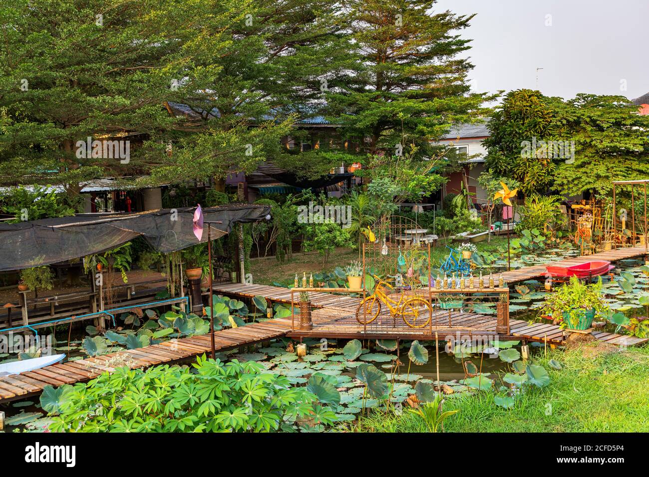 Farbenfroher Garten mit Spazierwegen über Teich in idyllischer Natur von Koh Kret, Bangkok, Thailand Stockfoto