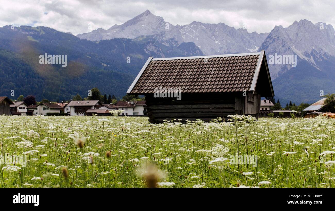 Holzhütte / Heuscheune in Garmisch-Partenkirchen mit Alpenpanorama Im Hintergrund Stockfoto