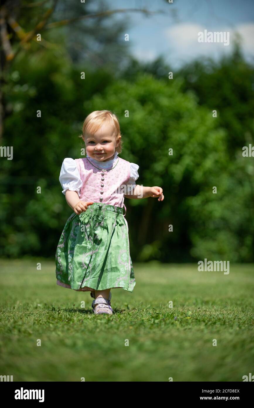 Mädchen in Dirndl läuft über eine Wiese, Oberbayern, Bayern, Deutschland Stockfoto