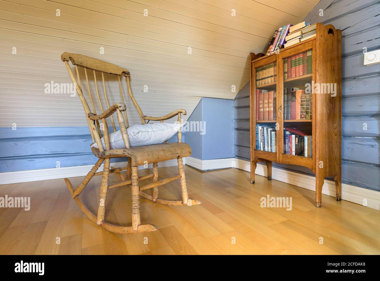Innenansicht des Wohnzimmerdetails traditionelles norwegisches Holzhaus, Holzstuhl und Bücherregal, Nordland, Norwegen Stockfoto