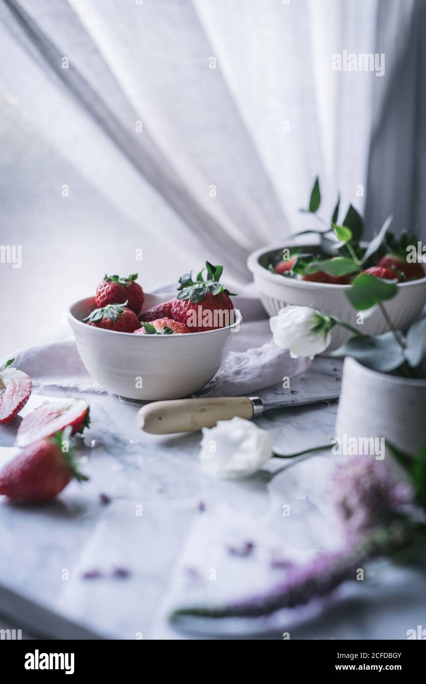 Erdbeeren und Blumen auf Marmortisch Stockfoto