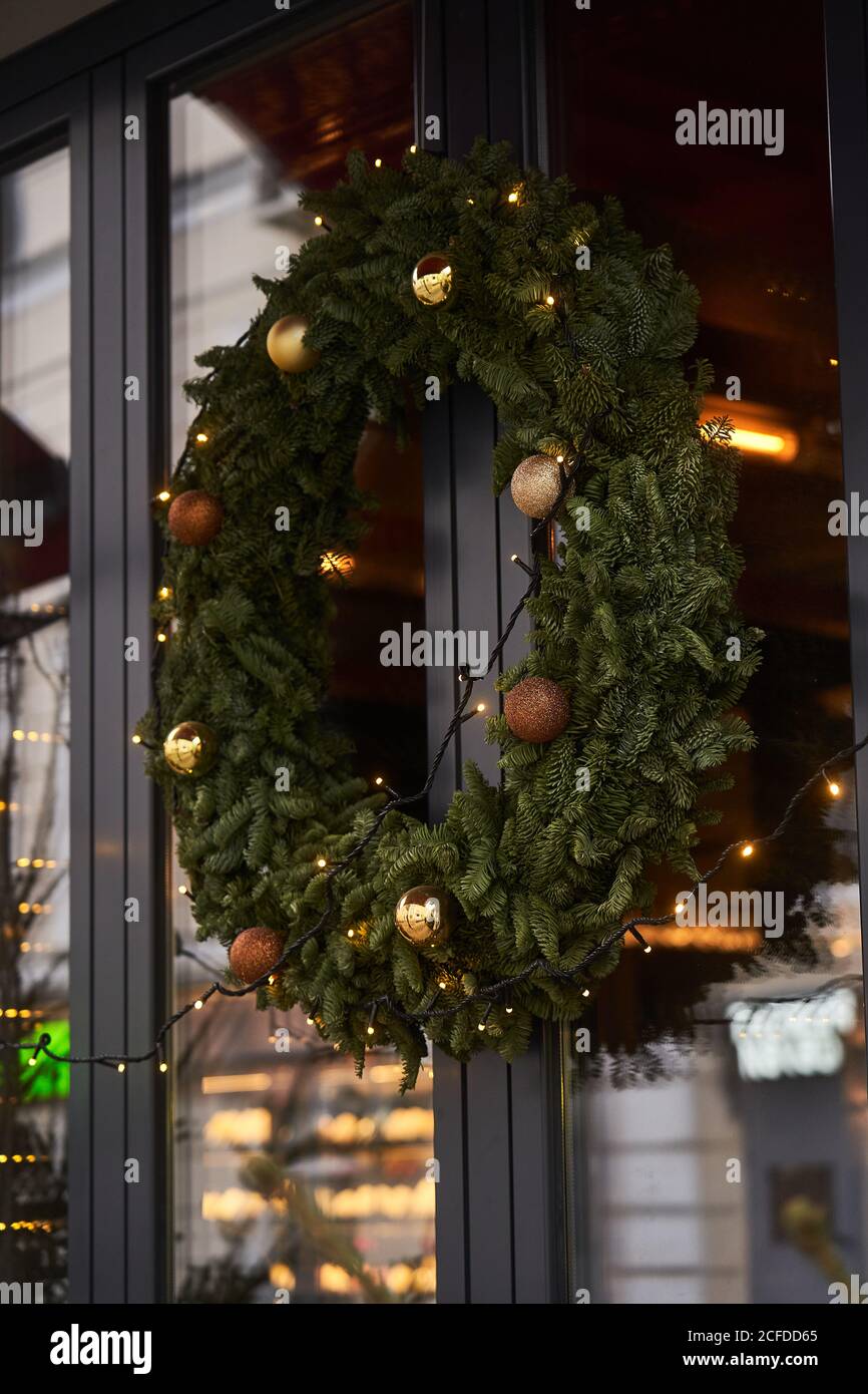 Fassade des Cafés mit bunten Dekorationen von Nadelbäumen und Weihnachtsbaum mit Girlanden bei Tageslicht Stockfoto