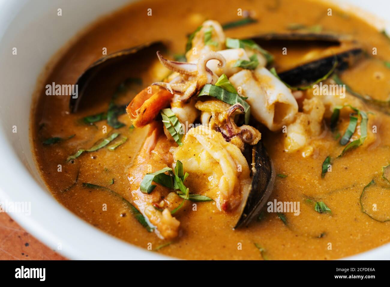 Von oben Nahaufnahme Ragout mit Fischmuscheln gekocht kleinen Tintenfisch Und Kräuter auf dem Teller im Restaurant Stockfoto