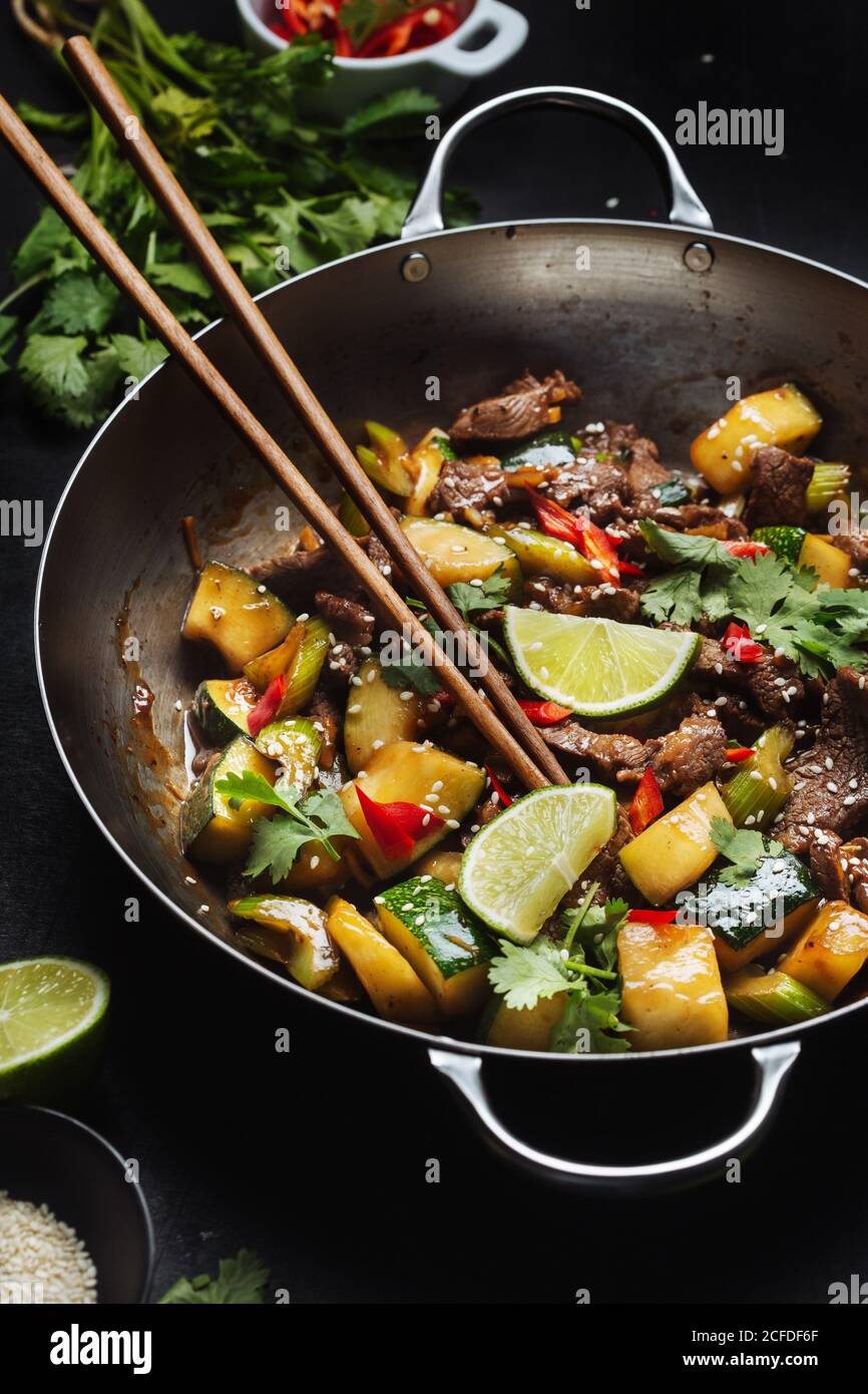 Von oben der asiatischen würzigen Wok rühren gebratene Gericht mit Fleisch  und Zucchini garniert mit frischer Limette und Koriander Stockfotografie -  Alamy