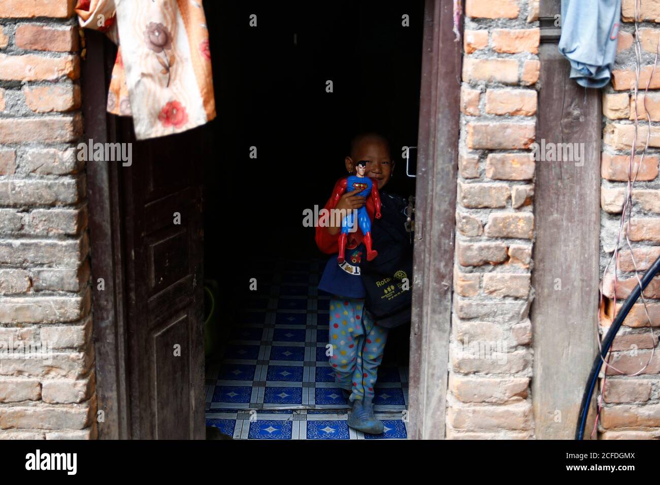 Lalitpur, Nepal. September 2020. Ein Kind reagiert, nachdem es in seinem halb gemieteten Zimmer während der Coronavirus-Sperre kostenlose Leckereien erhalten hat, um die Ausbreitung von COVID-19 in Mahalaxmisthan in Lalitpur, Nepal, am Samstag, 5. September 2020 einzudämmen. Kusum Tamang Poudyal lieferte heute Schultaschen mit Heften, Bleistiften, Farben, Geschichten und Spielzeug, die vom Rotary E-Club Nepal an Kinder von Saili Tamang gespendet wurden. Eine alleinerziehende Mutter von zwei Kindern, nachdem sie sich von ihrem Mann getrennt hatte, der seit zwei Jahren Alkoholiker war, nachdem er angefangen hatte, Dinge aus dem Haus zu stehlen und zu trinken und gewalttätig zu werden Stockfoto