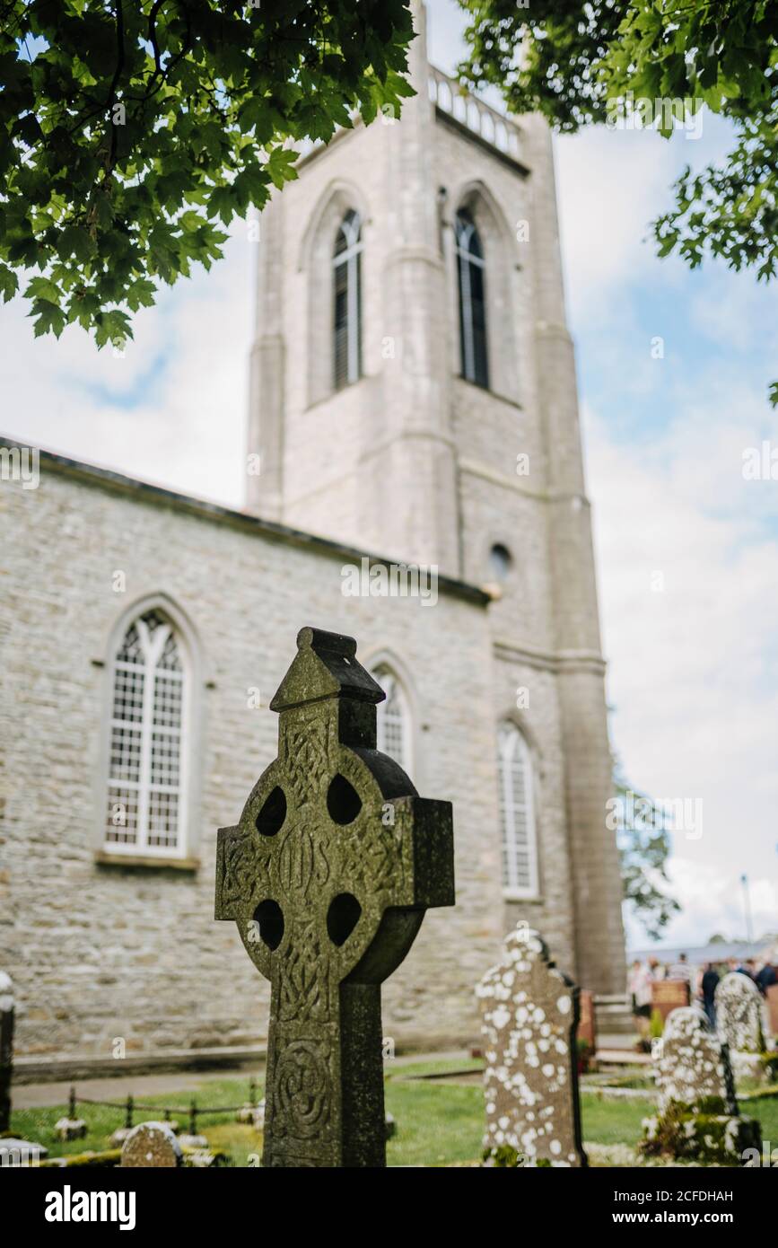 Grabstein in Form eines keltischen Kreuzes mit St. Columba's Church, Drumcliff, Irland Stockfoto