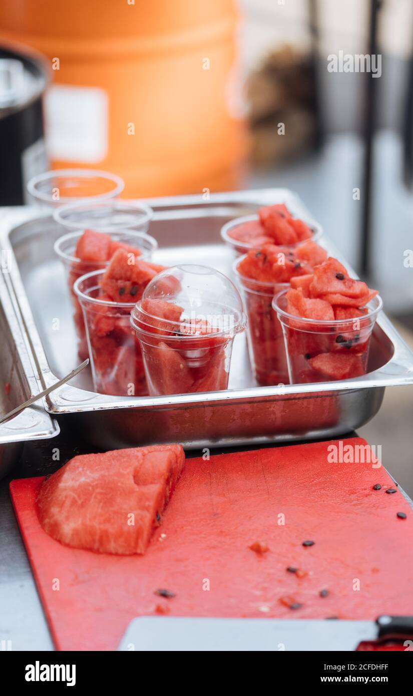 Von oben Plastikgläser von frischen Wassermelonen Stücke auf Metalltisch auf dem Markt Stockfoto