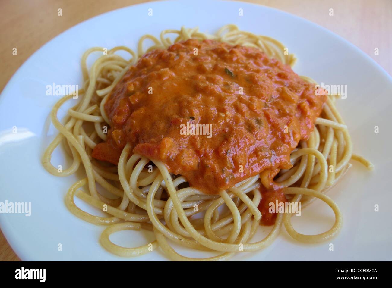 Ein Teller mit frisch gekochten Vollkornspaghetti Napoli mit Zwiebeln In die Sauce geben Stockfoto