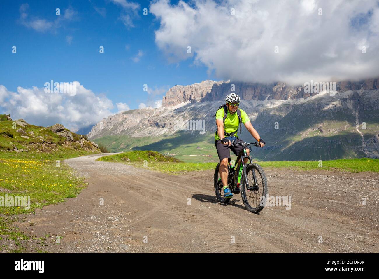 Radler mit Elektro-Mountainbike (E-Bike) entlang des Weges viel del Pan (Bindelweg) vor der Sellagruppe, an der Grenze zwischen Venetien Stockfoto
