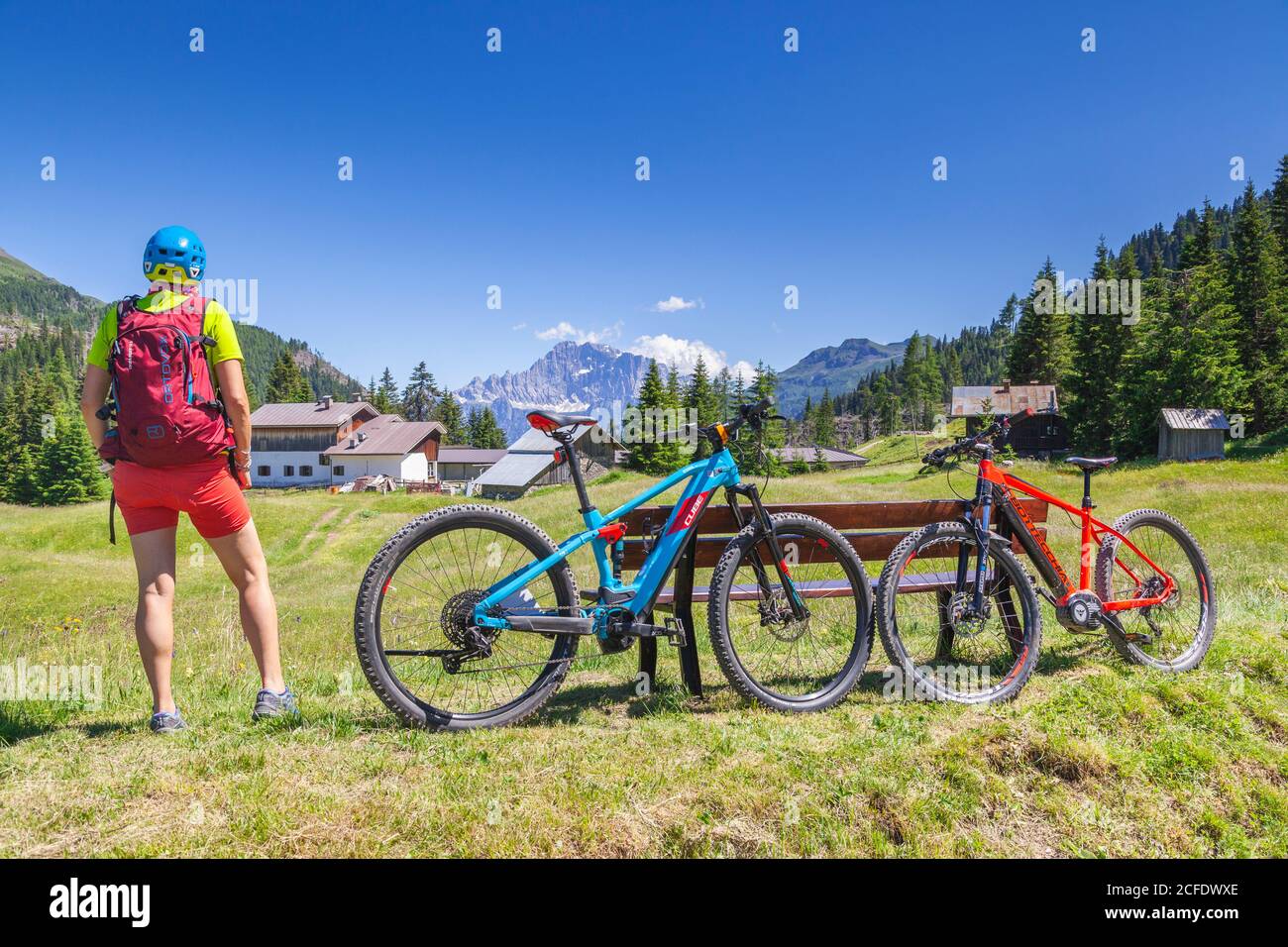 Frau steht vor dem Civetta Berg bei der Cherz alm, Tour mit E-Bike in der Naturlandschaft der Dolomiten, livinallongo del col di lana, Stockfoto