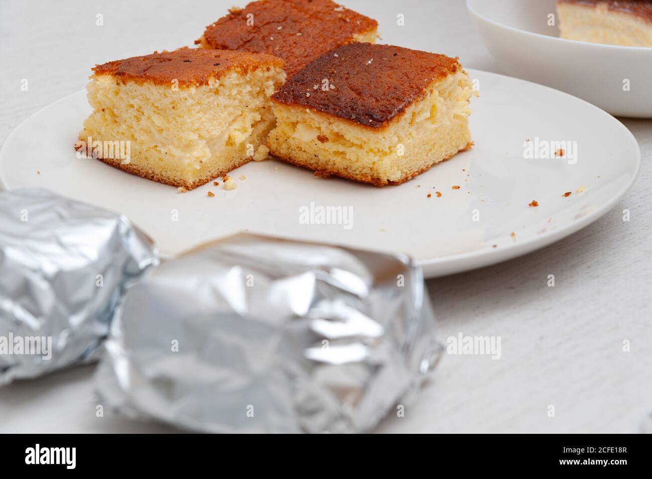 Traditionelle brasilianische Dessert (bekannt als Bolo Gelado) -  Herstellung Schritt für Schritt: Kuchen Stücke verpackt und nicht in  Aluminiumfolie eingewickelt. Selektiver Fokus Stockfotografie - Alamy