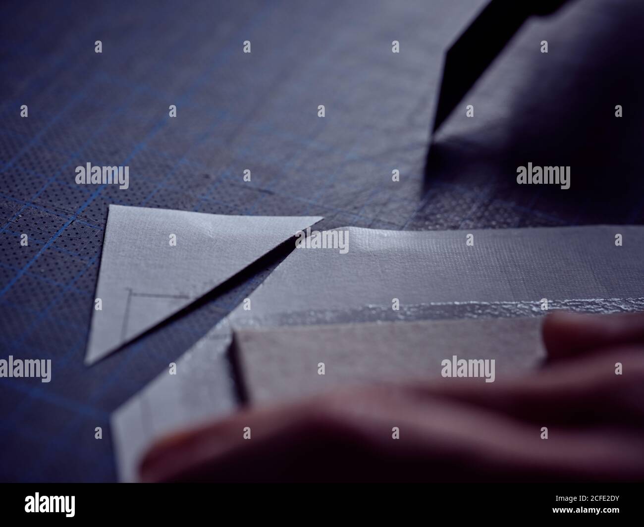 Arbeiter schneiden Blatt mit Schreibwarenmesser auf der Oberfläche Stockfoto