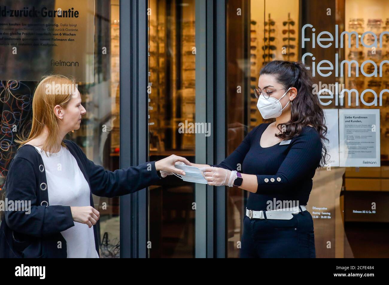 Must-Wear Maske beim Einkauf in Nordrhein-Westfalen erhalten Kunden bei Fielmann von einem Mitarbeiter eine Mund-Nase Maske mit FFP2 Maske und Stockfoto