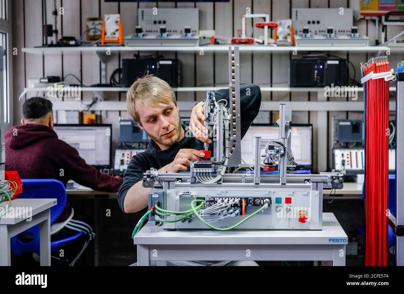 Remscheid, Nordrhein-Westfalen, Deutschland - Auszubildende in Metall- und Elektroberufen, ein Industriemechaniker montiert einen elektropneumatischen Stockfoto