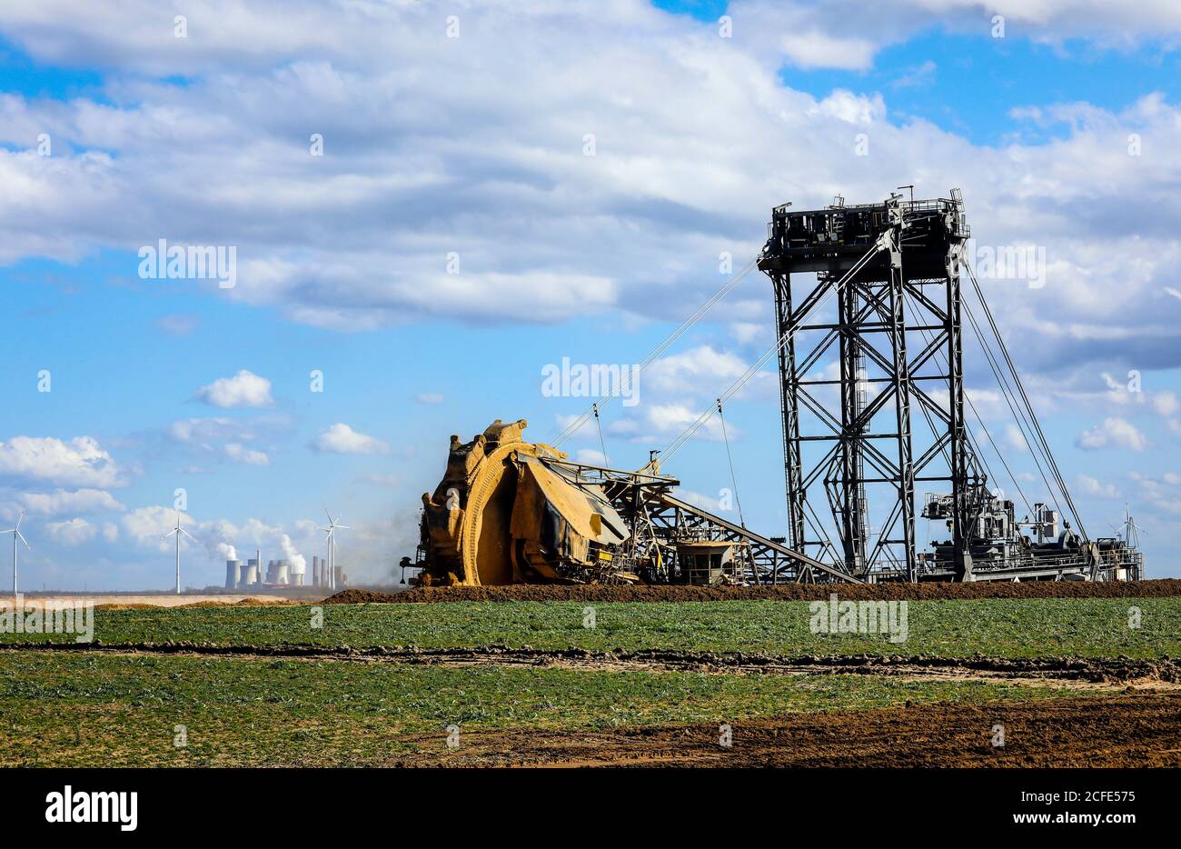 Schaufelradbagger in der RWE Braunkohlebergwerk Garzweiler Bagger am Abrissrand bei Keyenberg, ein Windpark im Hintergrund und die Stockfoto