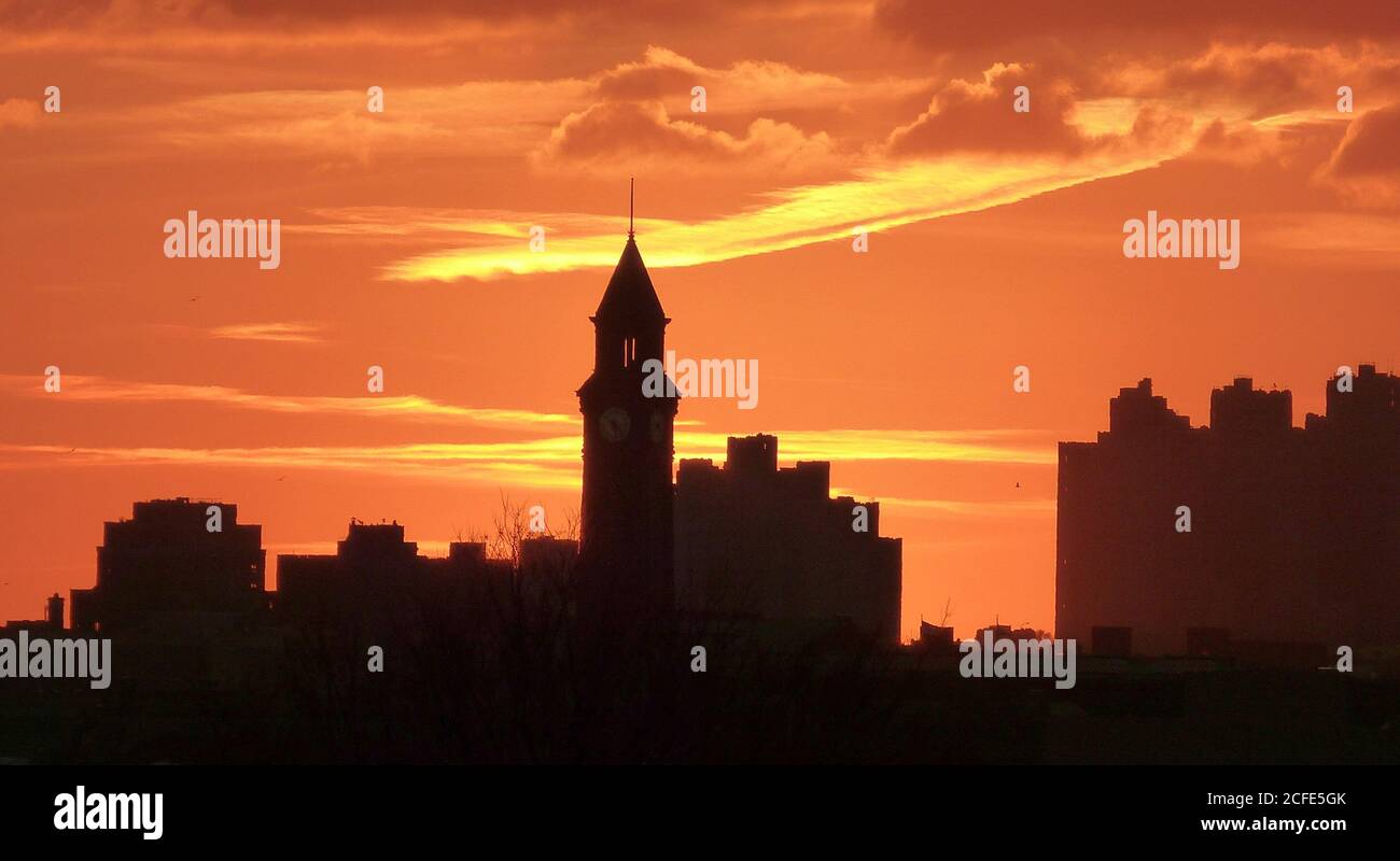 Roter Sonnenuntergang über New York City. Dramatischer Sonnenuntergang Himmel. Orangefarbener feuriger Himmel. Beeindruckender himmlischer Himmel. Spektakuläre gelbe Wolkenlandschaft am Himmel. Stockfoto
