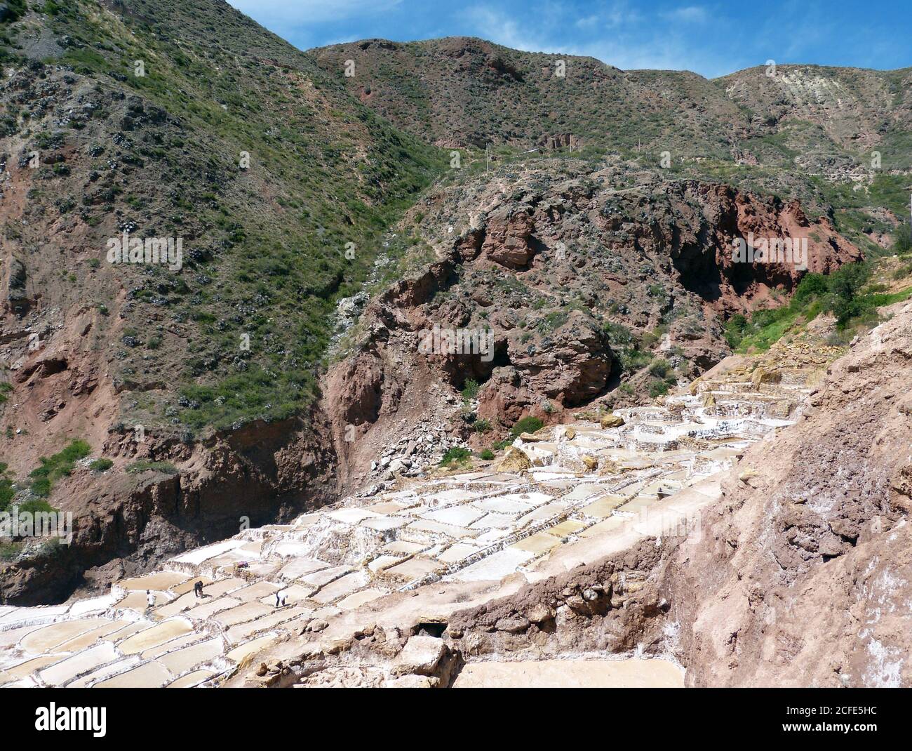 Alte Salzbergwerke in Salineras de Maras, Peru. Landschaftlich schöner Blick auf den Andenhang mit vielen Salzteichen. Peruanisches rosa Salz. Inka-Salzgewinnung. Stockfoto