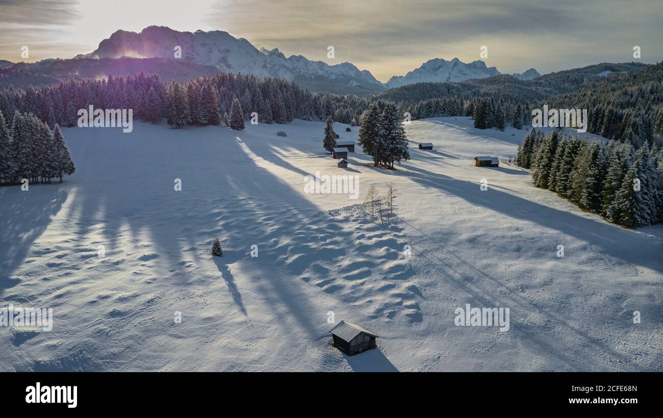 Holzstadel im Winter auf den Buckelwiesen vor Mittenwald mit Blick auf die Wettersteingebirge (Alpspitze, Zugspitze und Waxenstein), Stockfoto
